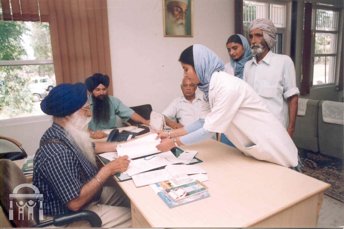 Budh Singh Dhahan in office at Guru Nanak Mission Medical and Educational Trust with nurses